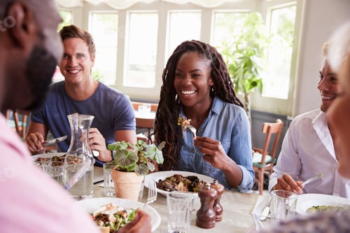 Preview: Group Of Friends Sitting At Table In Restaurant Enjoying Meal Together