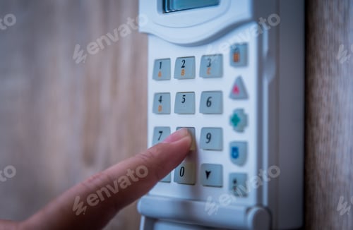 Preview: Close up of woman using intercom at building entrance.