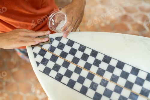 Preview: Top view of a man sanding a surfboard