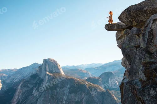 Preview: Aerial shot of a person in a dinosaur costume standing at the edge of a cliff and enjoying the view