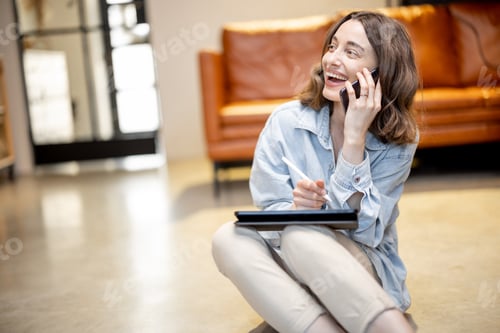 Preview: Woman works on a digital tablet while sitting on the floor