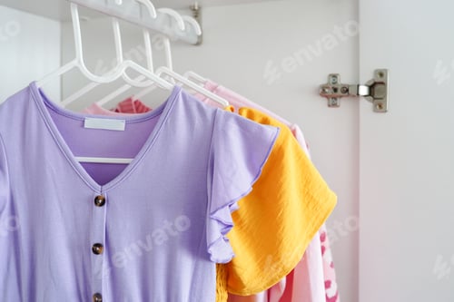 Preview: colorful children's clothes, including a lilac dress with ruffled sleeves