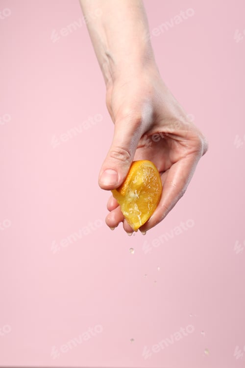 Preview: Woman squeezing orange on pink background, closeup. Space for text