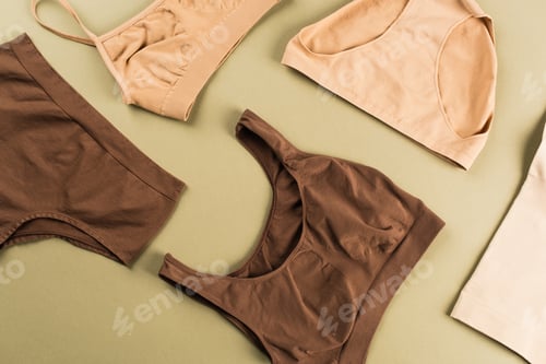 Preview: Top view of brown and beige cotton underwear on green background