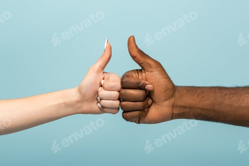 Preview: cropped view of interracial couple showing thumbs up isolated on blue