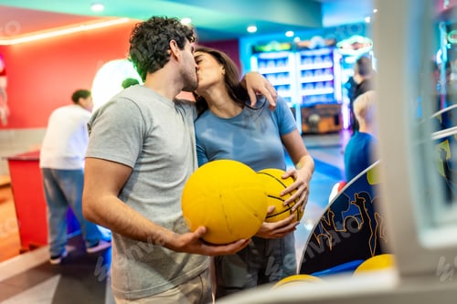 Preview: Happy couple kissing and holding balls in entertainment center
