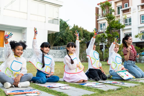 Preview: Group of student coloring on painting board outdoors in school garden.
