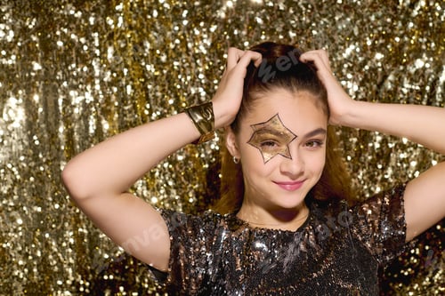 Preview: Cute girl with star face paint shines bright in golden sequins during Halloween fun