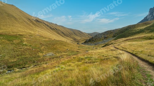 Preview: Peaceful mountain valley trail in Georgia surrounded by rolling hills of the Caucasus Mountains.