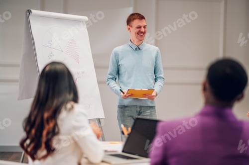 Preview: Redhead businessman holding a presentation during a meeting in an office
