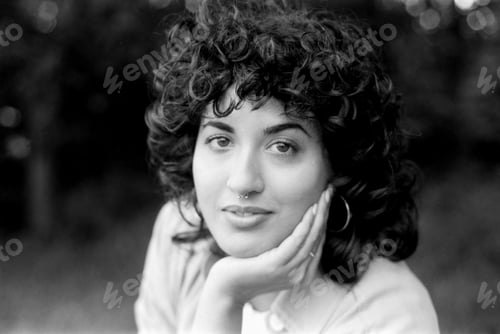Preview: Young woman with curly hair posing in monochrome analog portrait