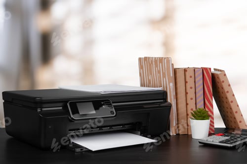 Preview: Stack of books and home printer against blurred background