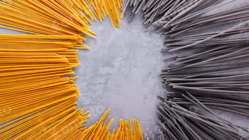 Preview: Black And Yellow Pasta On A Gray Background. Yellow And Black Spaghetti On Cement Background. Raw