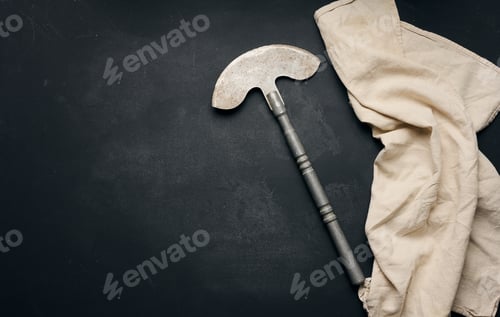 Preview: Big kitchen knife on black table with cotton napkin, top view