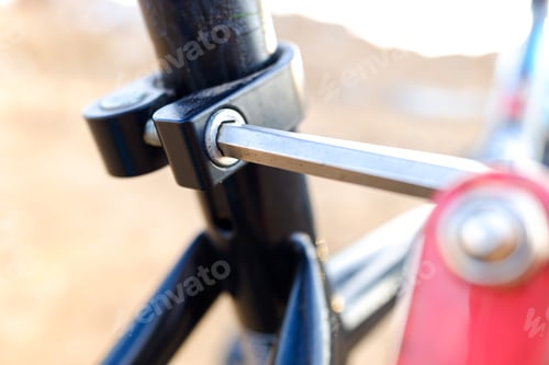 Preview: Child tightened the saddle nuts of his bicycle.