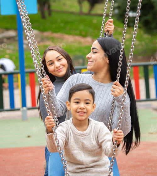 Preview: Happy family having fun on swings at playground
