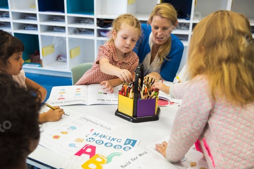 Preview: Group of diverse Kids coloring workbook in class