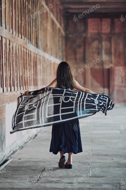 Preview: East asian woman in black dress dancing with translucent scarf among columns of ancient temple