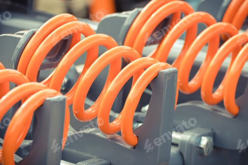 Preview: Big and hard orange steel spring as part and detail of industrial or agricultural machine