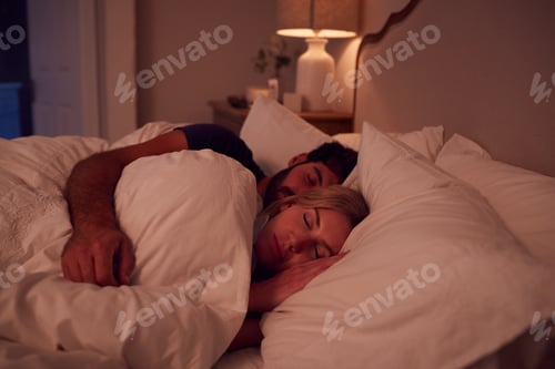 Preview: Night Shot Of Peaceful Couple Asleep In Bed Cuddling Together