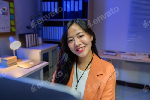 Preview: Young Asia businesswoman working late using desktop computer in office at night