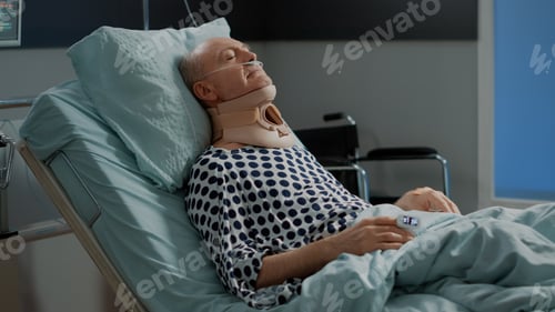 Preview: Old patient sitting in hospital ward bed with neck collar