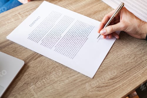 Preview: Man signs a contract at a desk in a company office