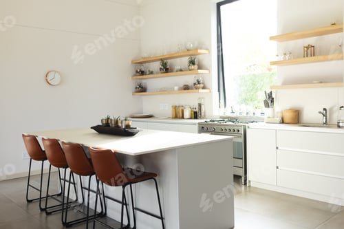 Preview: A modern kitchen features a central island with brown stools and white cabinetry, with copy space