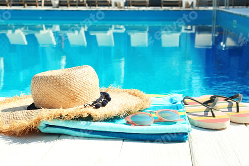 Preview: Beach accessories on wooden deck near swimming pool