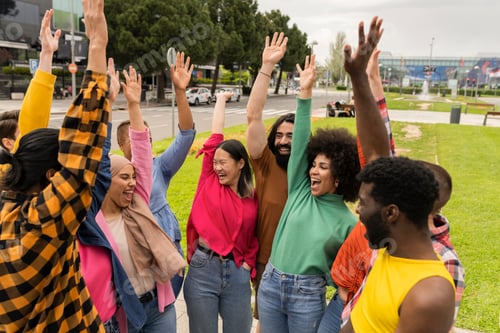 Preview: Multiracial group of several young people raising their hands happily. Celebrating outdoors.