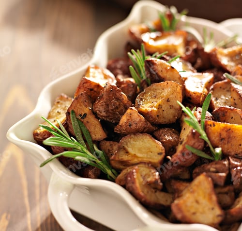 Preview: rosemary herb potatoes in white baking dish close up.