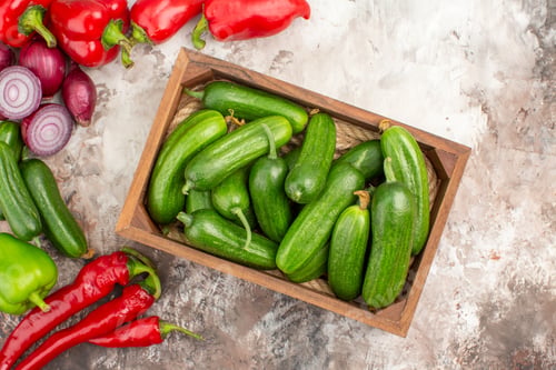 Preview: Above view of fresh natural organic vegetables in a wooden basket and on mixed color table