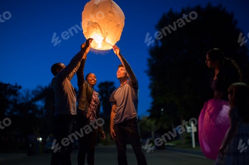 Preview: Friends holding up sky lantern to celebrate