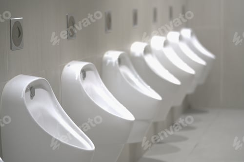 Preview: Close up row of indoor urinals men. toilet room interior background on modern tower.
