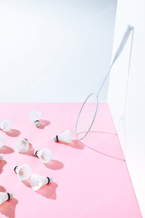 Preview: badminton racket and shuttlecocks on pink paper at wall