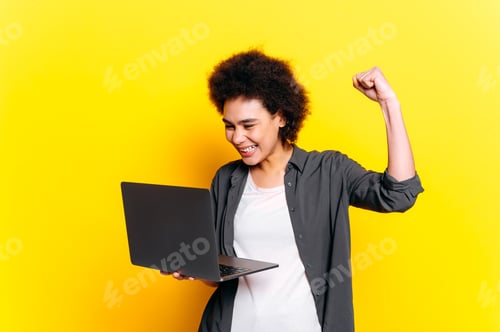 Preview: Good job. Joyful african american or brazilian young woman with short curly hair, holding laptop