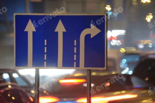 Preview: Direction road signs with blurred cars on city street traffic at night. Urban transportation concept