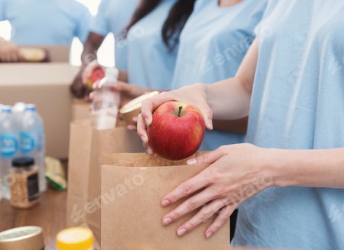 Preview: Volunteers packing food and drinks into paper bags