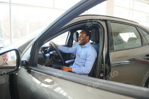 Preview: Portrait Of Excited Young African American Guy In Dealership Showroom