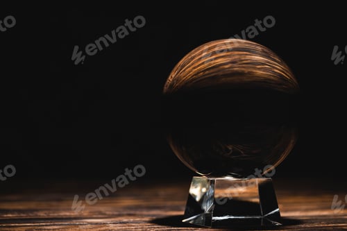 Preview: crystal ball on wooden table on black background
