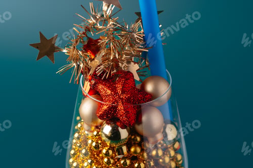 Preview: Glass with Christmas decorations on dark green background