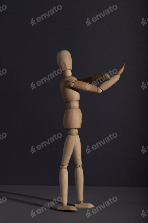 Preview: Wooden mannequin shows obscene gesture fuck off with hands on gray background. protest