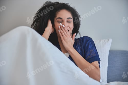 Preview: Relaxed international female person covering her mouth