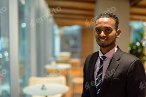 Preview: Portrait of handsome young African businessman in coffee shop