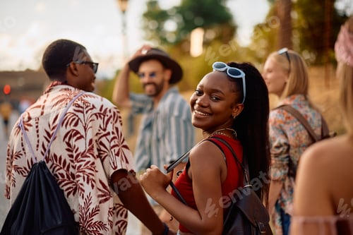 Preview: Happy black festival goer and her friends attending open air music concert in summer.