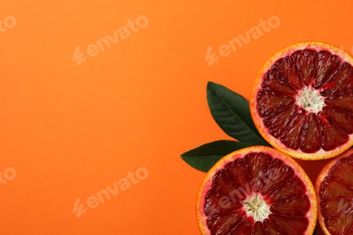 Preview: Red orange halves and leaves on orange background