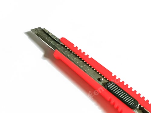 Preview: Close up photo of red utility knife isolated on white background.
