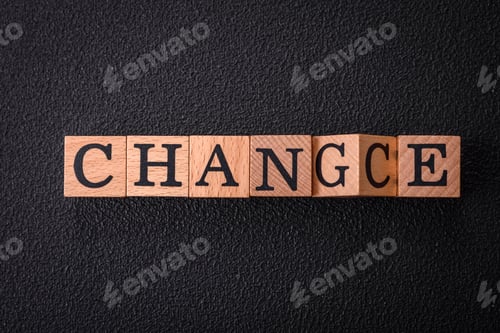 Preview: The inscription chance or change with wooden cubes on a dark concrete background
