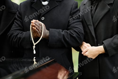 Preview: Close up of people holding rosary at funeral