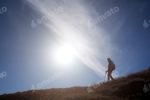 Preview: Young woman hiker with a backpack on the top of the mountain